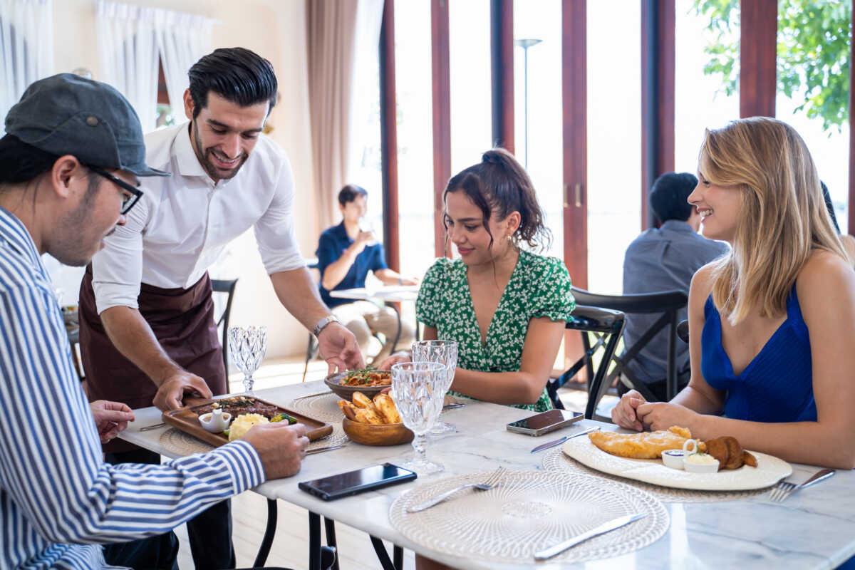 Group of diverse friend talking and eating food together in restaurant. Attractive young man and woman people feel happy and relax, having fun hangout indoors enjoy meeting reunion in cafe cafetaria.